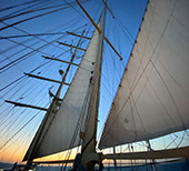 Vele di un veliero al tramonto